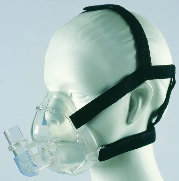 Eine durchsichtige Mund-Nasen-Maske mit Kopfbändern an einem Übungskopf; vorn der Anschluss für den Beatmungsschlauch.