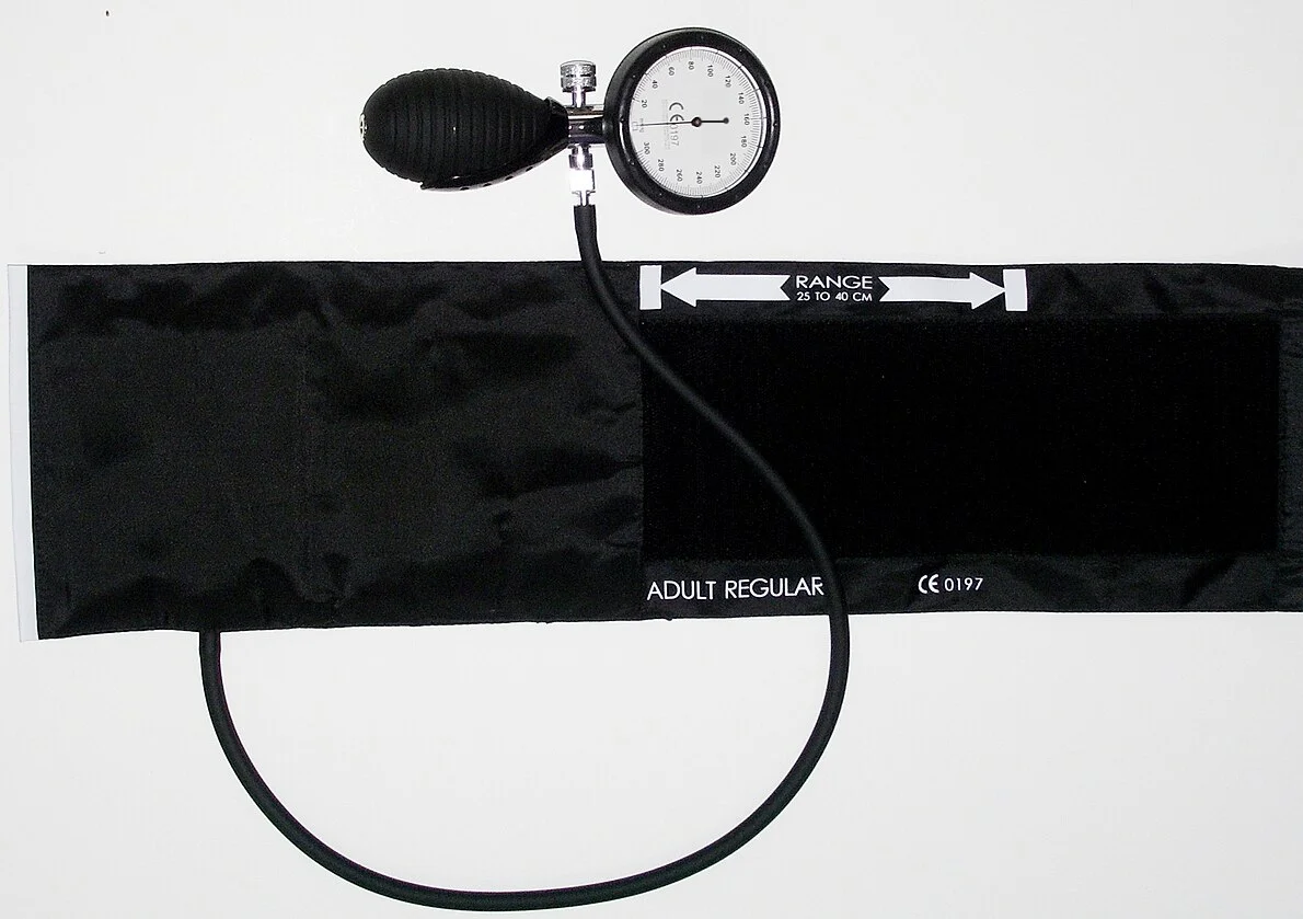 Manuelles Blutdruckmessgerät mit Pumpball, Ablassventil und Zeigermanometer bis 300 mmHg, verbunden mit einer ausgebreiteten Oberarmmanschette; auf der Manschette sind ein Armumfangsbereich von 25 bis 40 cm und die Größenangabe für Erwachsene aufgedruckt.