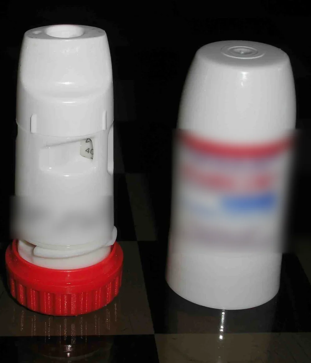 Zwei Pulverinhalatoren mit Budesonid/Formoterol: links ein Gerät ohne Schutzkappe mit Mundstück, Dosisanzeige und rotem Drehgriff, rechts ein geschlossenes Gerät mit unkenntlich gemachtem Etikett.