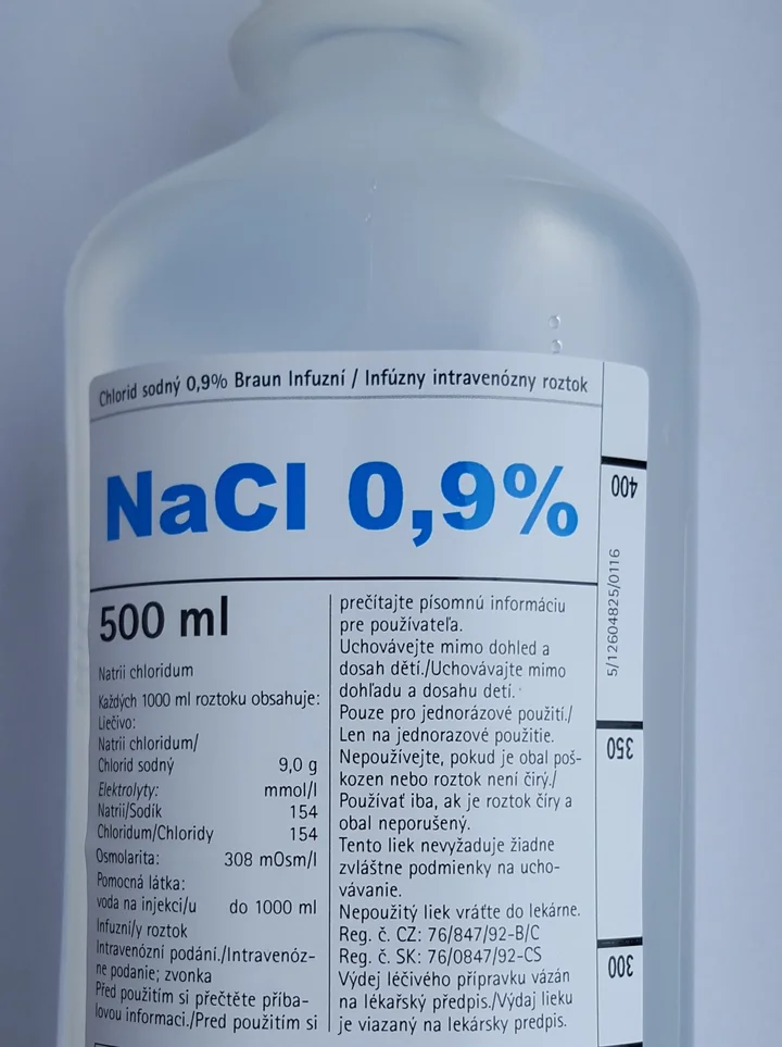 Oberer Teil einer 500-ml-Infusionsflasche mit dem Etikett „NaCl 0,9 %“; in der tschechisch-slowakischen Inhaltsangabe stehen Natrium 154 mmol/l, Chlorid 154 mmol/l und 308 mOsm/l.